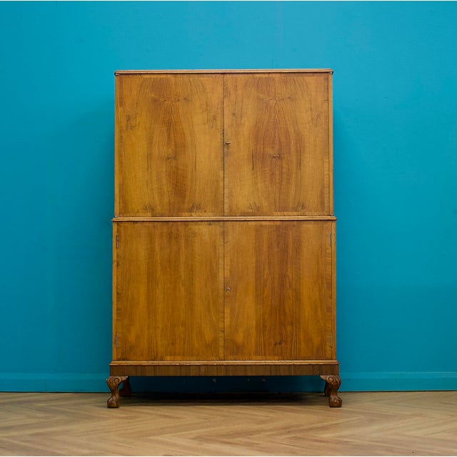 1930s walnut veneered drinks cabinet, crafted with beautifully figured veneers to the doors and finished in a warm mid-...