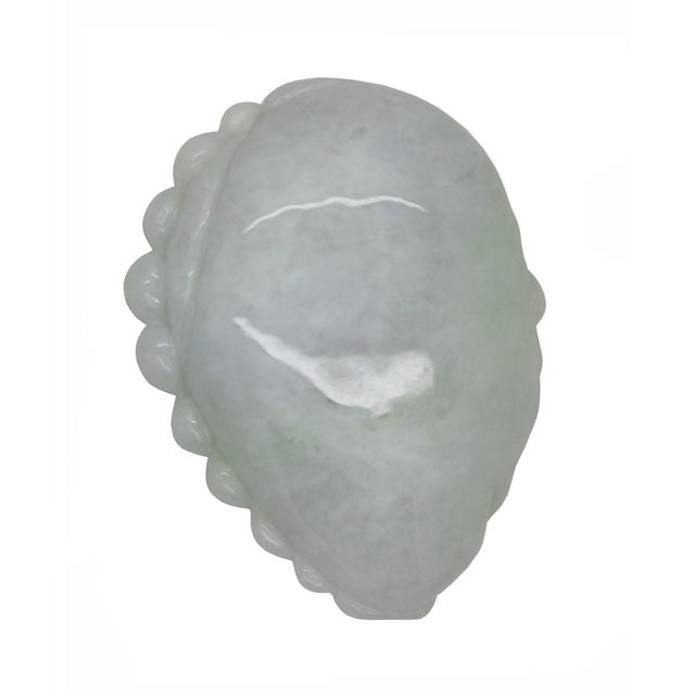 This jadeite carving depicts Budai, the Laughing Buddha, rendered in a pale, translucent celadon green with subtle mottled...