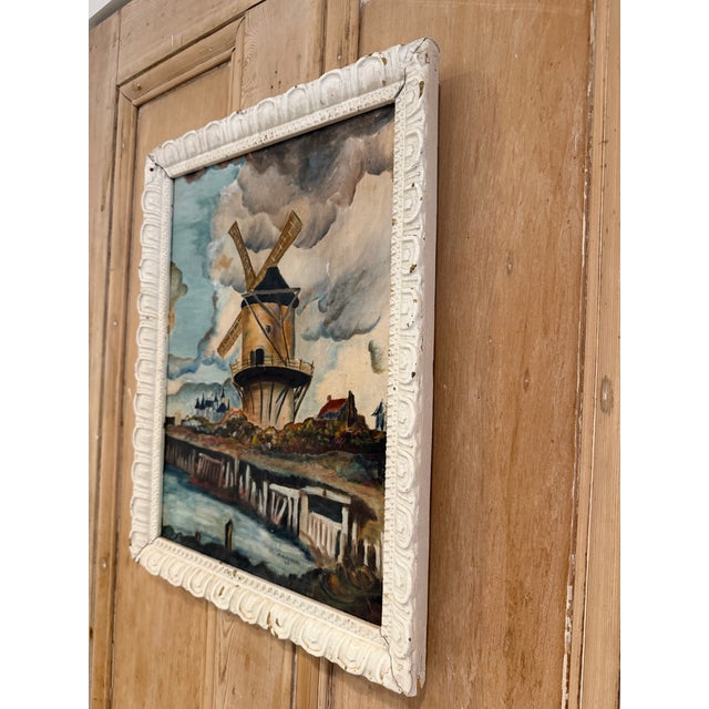 A charming vintage oil painting featuring a classic windmill set against a dramatic, moody sky. Beautifully framed in an...