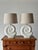 A pair of sculptural table lamps with nautilus shell-form plaster bases, each featuring a deeply ridged spiral design in a...