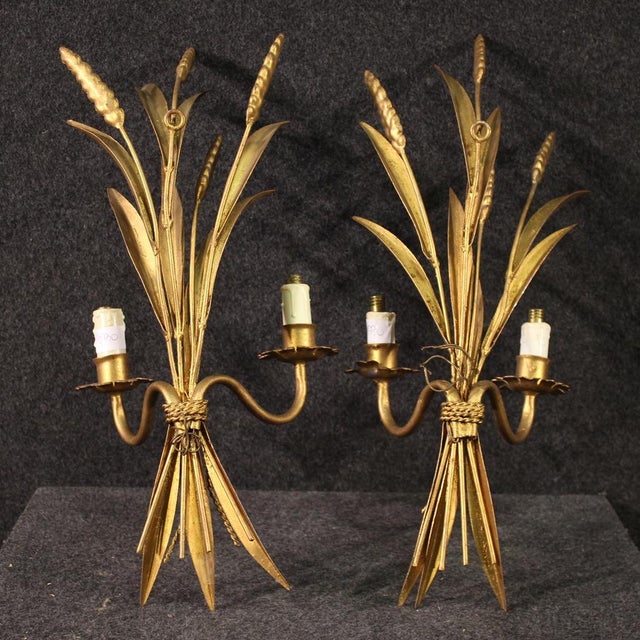 Pair of French wall lights from the 60s/70s. Wrought iron and gilded objects (bronze color) with decorations that recall...