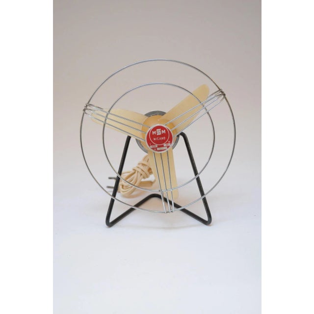 Small Italian modernist fan in red and beige with adjustable, black-metal base (ca. 1960s, Italy). The pointed edge of the...