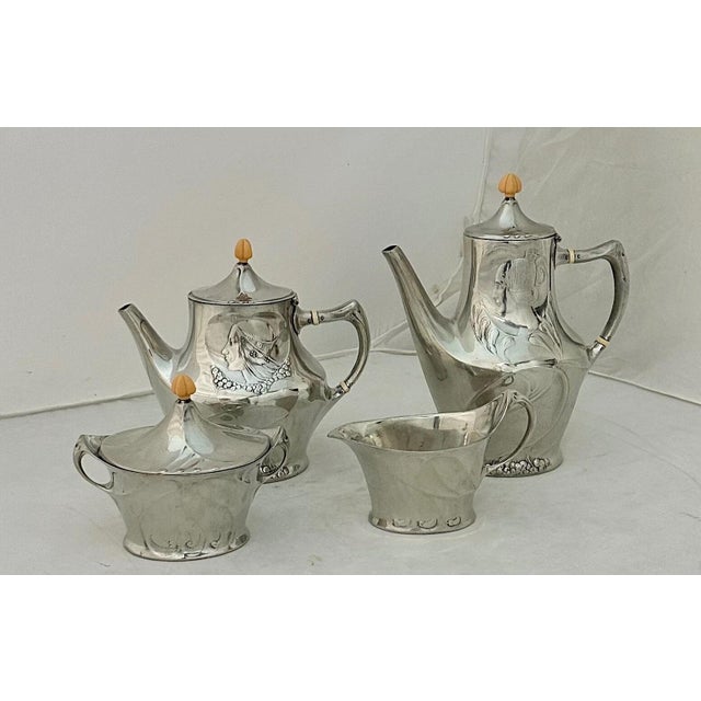 This vintage early 20th century tea service with serving tray is designed & produced by “Liberty & Co.”. The high polished...