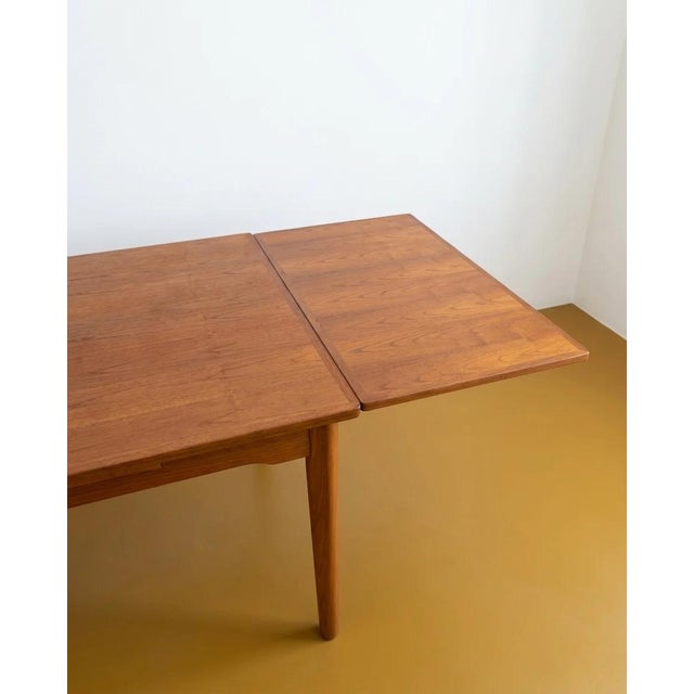 Vintage 1960s Danish teak table with two butterfly extension leaves, an elegant design with rounded corners, perfect for...
