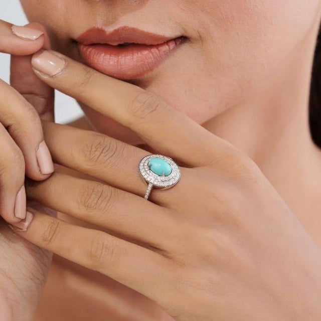 This cocktail ring featuring a 1.51 carat natural cabochon oval cut turquoise, set in 14k white gold. The center stone...