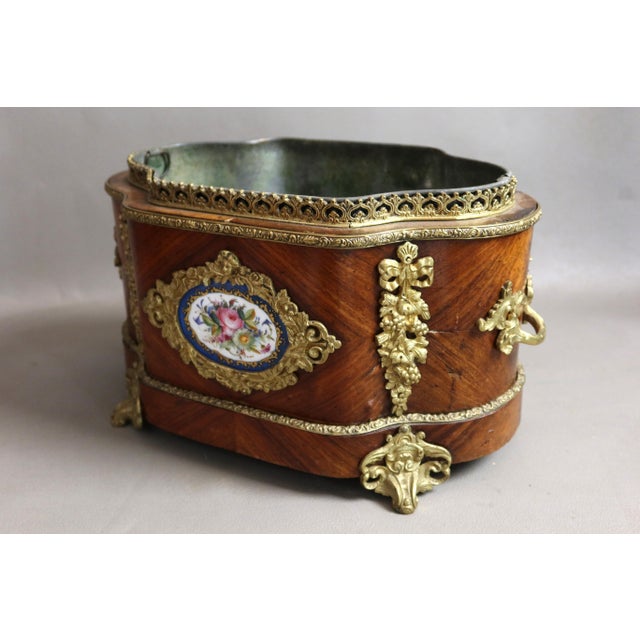 Wooden planter with a zinc interior. Beautiful gilt bronze ornamentation and a painted porcelain plaque on the front. Good...