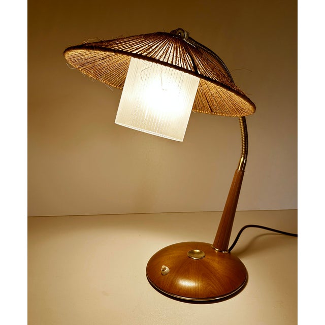 Vintage mid century desk lamp, featuring a sisal and glass shade mounted on a brass flex stem, teak base with star shaped...