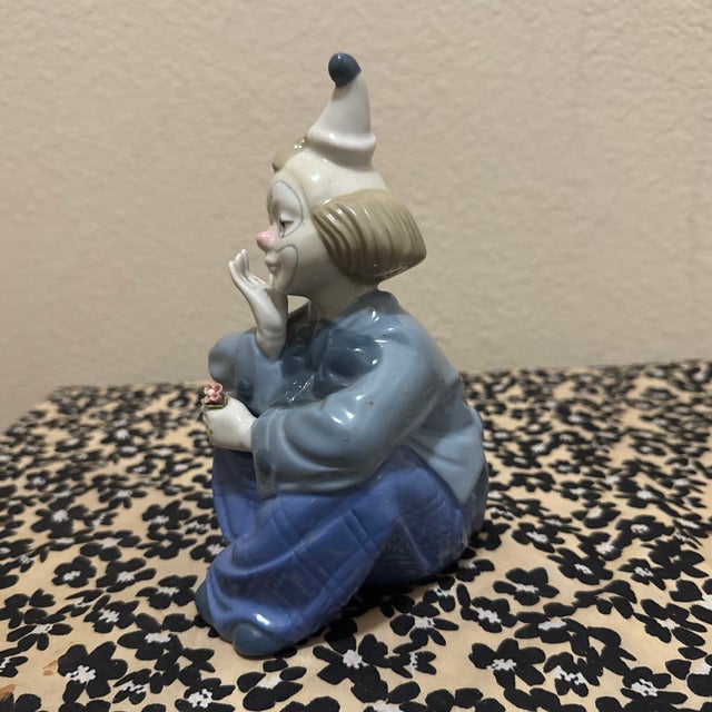 This charming vintage porcelain figurine depicts a soulful, pensive clown in a seated pose. Crafted by the renowned...