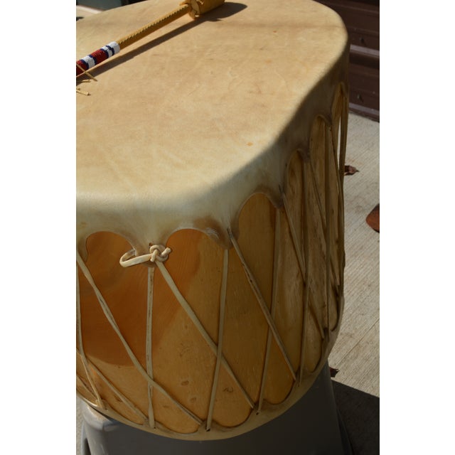 Great shape ! I do not know the history of it. Well made heavy & solid drum. Rawhide & wood. The beaded & suede mallet is...