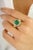 This exquisite ring is crafted in luxurious 14k yellow gold, featuring a vibrant 3.46 carat emerald-cut green gemstone as...