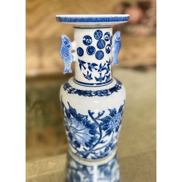 Chinoiserie blue and white ceramic vase with dynamic design in Asian motifs. Fish handles at both sides. Circa mid 20th...