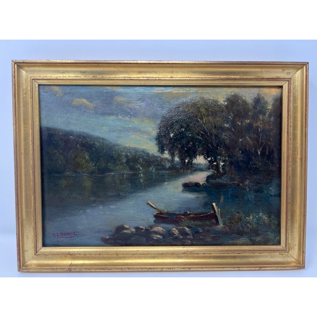An atmospheric early 20th century oil on canvas depicting a tranquil river landscape with a moored boat at the shoreline....