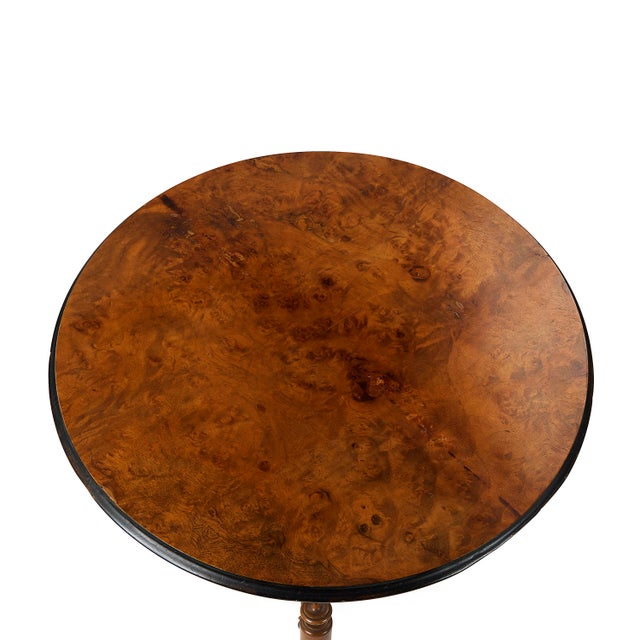 This striking antique occasional table with an exceptionally beautiful figured burl wood top and an elaborately turned...