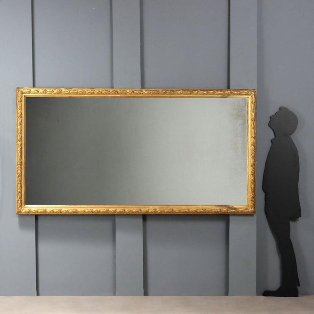 Carved and gilded beechwood mirror. Molded frame completely carved with laurel leaves. Italy, late 19th century. This...