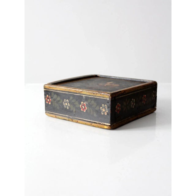 This is a vintage hand-painted wooden box from the early 20th century. The wood box features a slide out top with four...