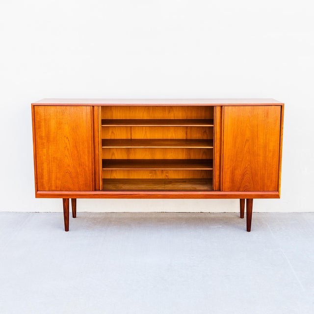 Refinished Scandinavian teak sideboard / credenza on tapered legs, made in Denmark c. 1960s. At 79" wide and 42" high, it...