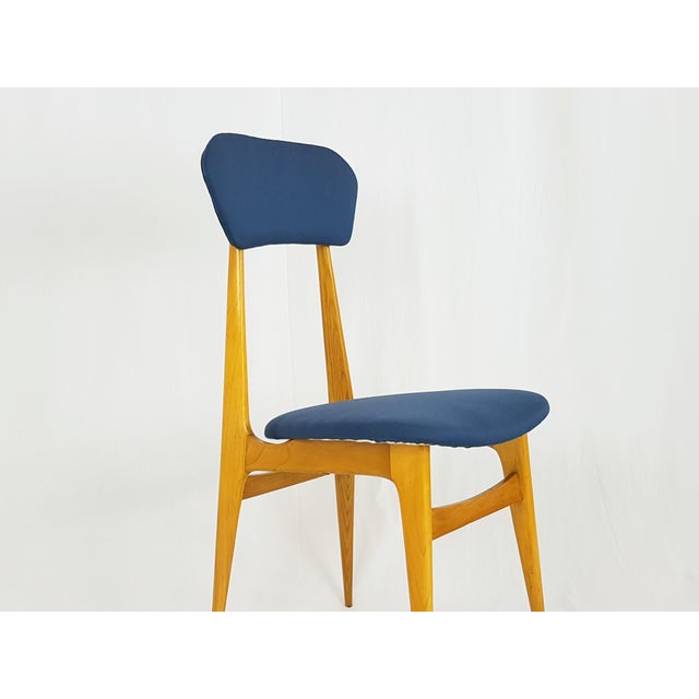 This beautiful mid-century chair was produced in Italy with a thin and willowy wooden structure. The blue fabric cushioned...