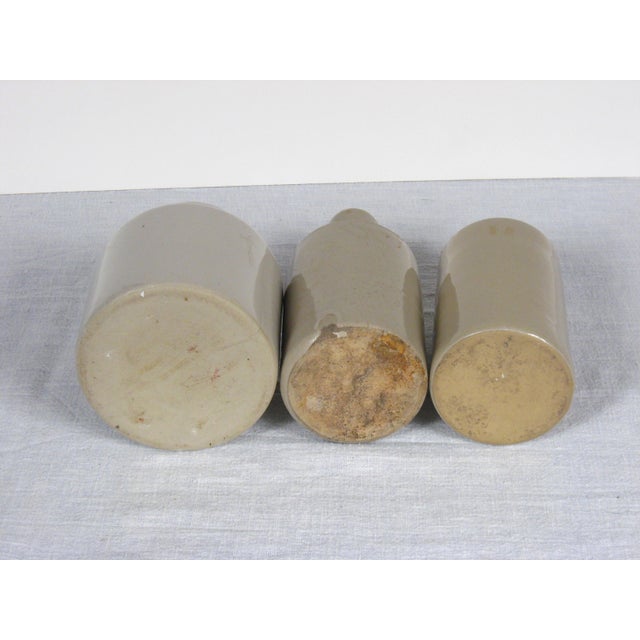 Set of three small vintage glazed earthenware crocks from England. One on the far right has a pouring spout. Heights left...