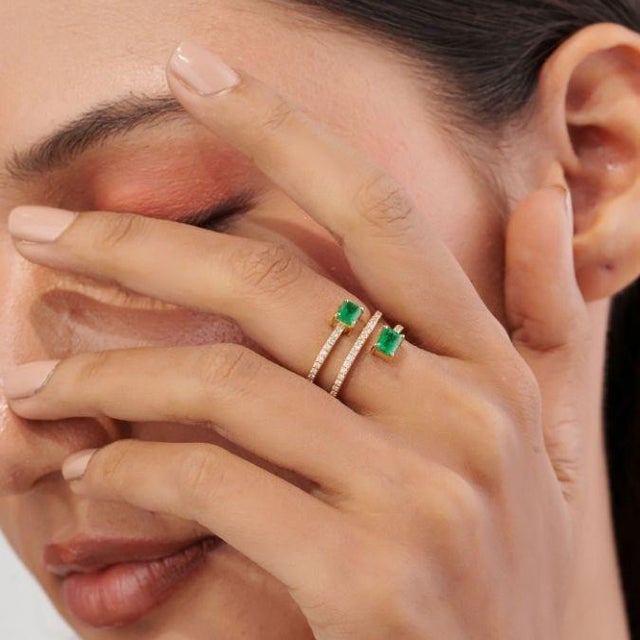 This handcrafted spiral wrap ring showcases 0.8 carats of natural emeralds set in 14K yellow gold. The two emeralds, each...