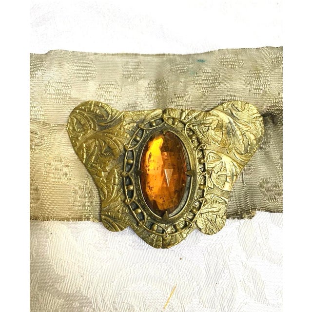 This antique belt from the 1910’s features a beautiful amber-colored stone buckle that will add a touch of vintage glamour...