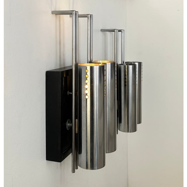 Pair of wall sconces with a chromed metal and blackened oak frame, produced in france in the 1970s. a third sconce is also...