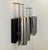 Pair of wall sconces with a chromed metal and blackened oak frame, produced in france in the 1970s. a third sconce is also...