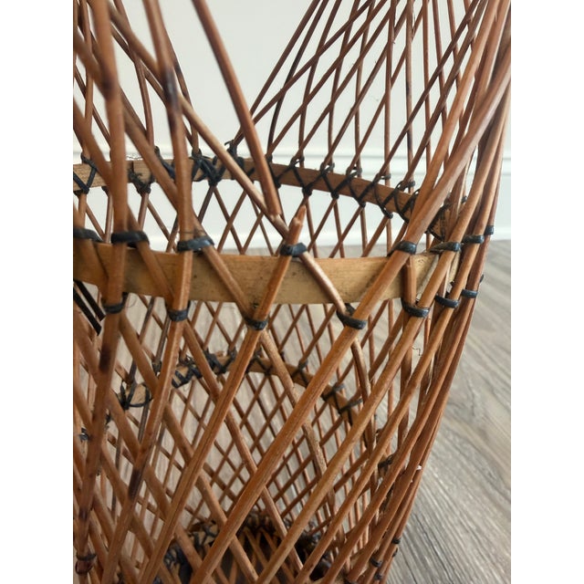 Vintage bamboo Ikebana basket features tall cylindrical shape with prominent rounded handle. The basket is woven of thin...