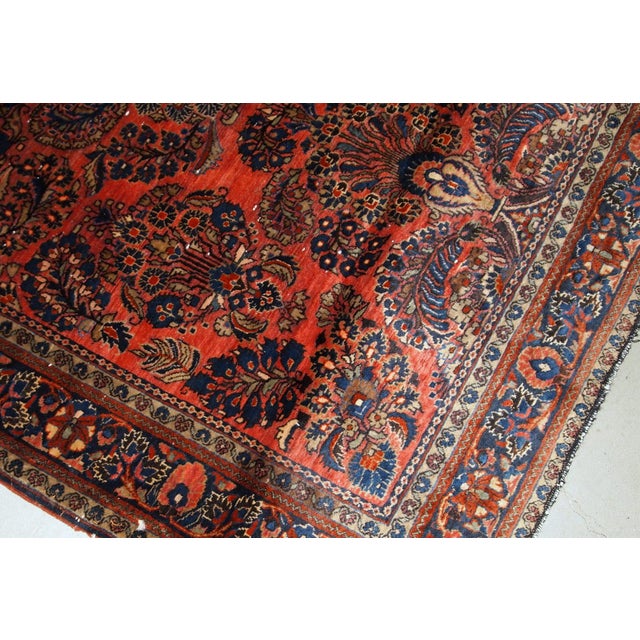Handmade antique Sarouk rug in original good condition. The rug has been made in the beginning of 20th century in red...