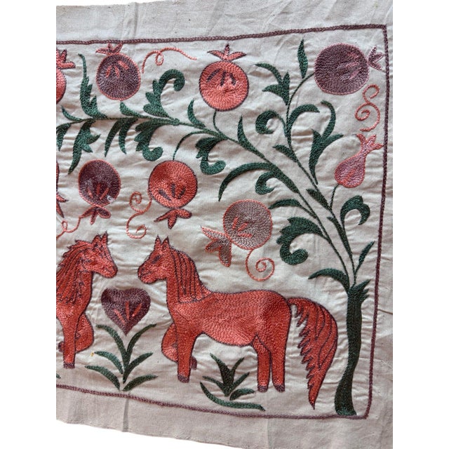 Hand-embroidered Suzani panel from Uzbekistan, worked in fine floss on a cream cotton ground. Two coral horses and a grey...
