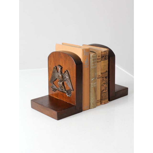 This pair of vintage eagle bookends features cast metal eagle plaques mounted to richly toned wood bases with softly...