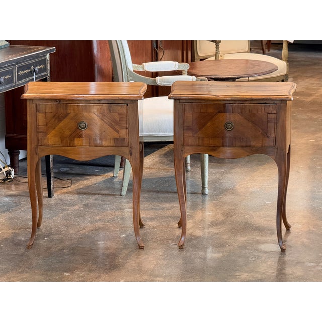 Italian walnut side tables with a single drawer each, the fronts veneered in a chevron parquetry pattern that radiates...