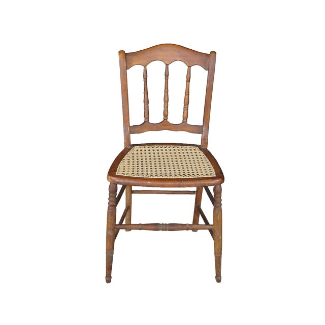 Vintage French-inspired or cottage-style dining side chairs showcasing a warm, honey-toned maple finish. Each chair...