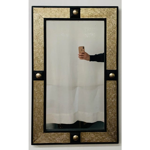 Hollywood Regency style mirror ebonized on brass, The mirror has a rectangular frame of ebonized wood flanking a brass...