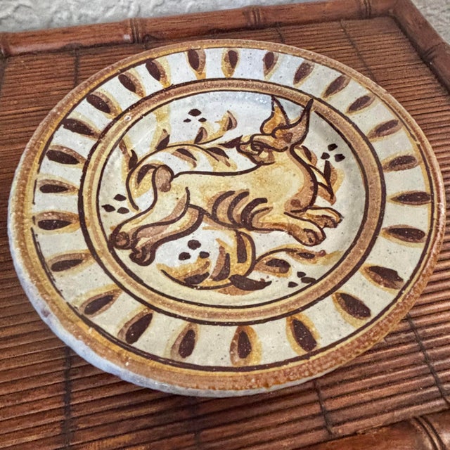 Rustic European earthenware wall plate with an animal motif, likely a fox. Hangs with a metal wall hanger. Signed by its...