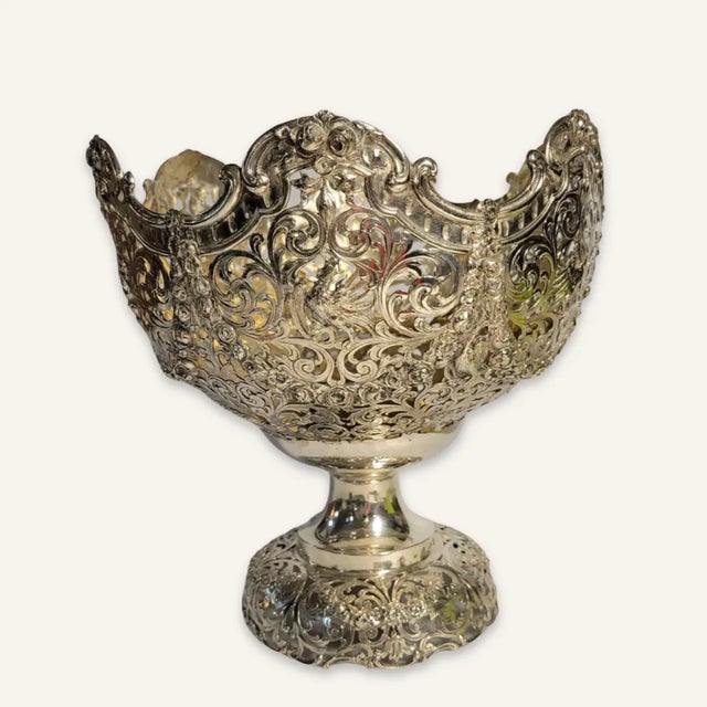 This dramatic footed coin silver centerpiece is decoratively pierced to the bowl. The interior is parcel gilt and in very...