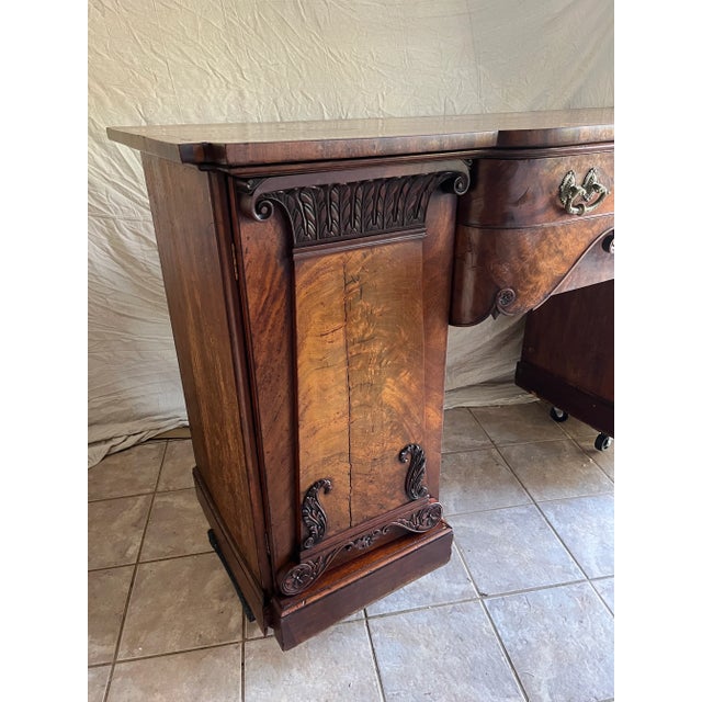 A single antique mahogany sideboard or buffet featuring a two cabinet base and shaped single drawer top with original...