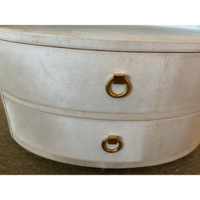 Elevate your space with our stunning white cowhide side table, featuring a gold door knocker-style knobs. This elegant...