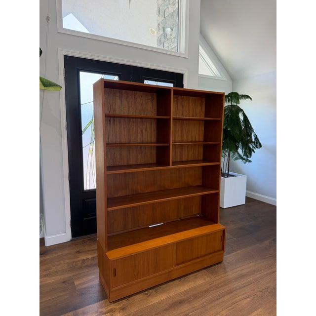 A beautifully engineered 1960s Danish Modern teak media bookcase and credenza designed by Carlo Jensen for Hundevad & Co.,...