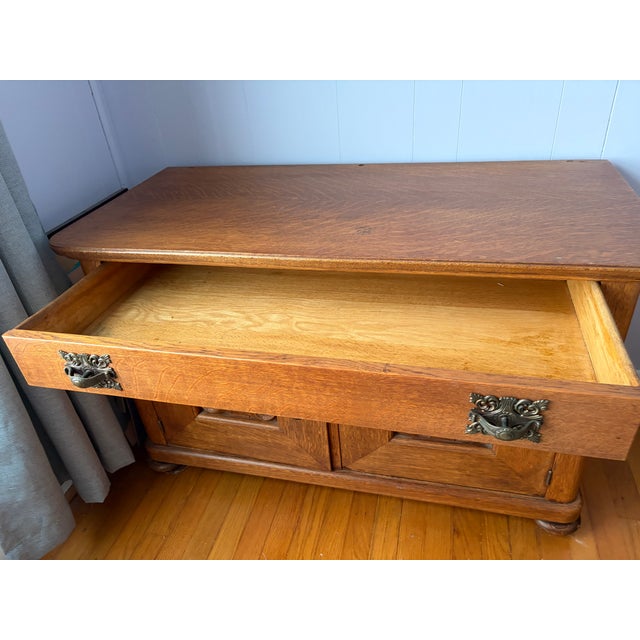 A truly exceptional example of late Victorian craftsmanship, this solid quartersawn oak sideboard commands attention with...