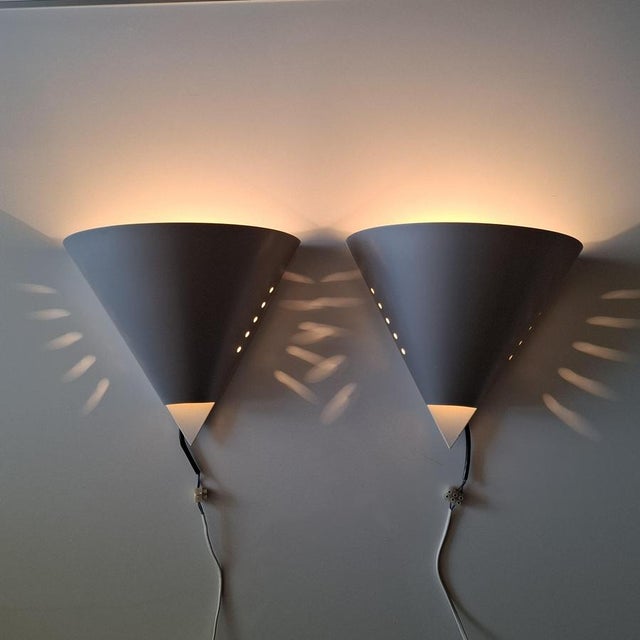 A very rare model, c1642, by raak amsterdam, captivates with its clean, geometric form: a conical metal shade with a matte...