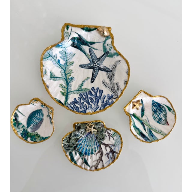 This exquisite set of four handcrafted shell trinket dishes features natural shells adorned with refined coastal...