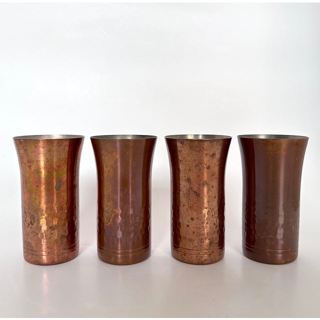 Set of 4 vintage Chinese hand-hammered copper-plated tin cups with Bauhaus styling. The cup's hammered decoration starts...