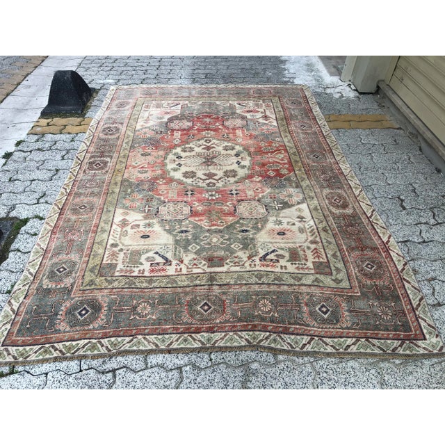 This is a vintage Turkish Oushak rug from the 1960s. The piece was hand-knotted.
