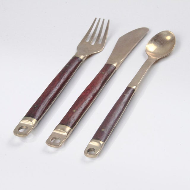 A modern brass and wood cutlery set designed by Carl Cohr in the 1960s in Denmark. This elegant set, comprising six...