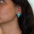 A bold pair of Sleeping Beauty turquoise cabochons in clean, robin's-egg blue anchors these solid 14K yellow gold stud...
