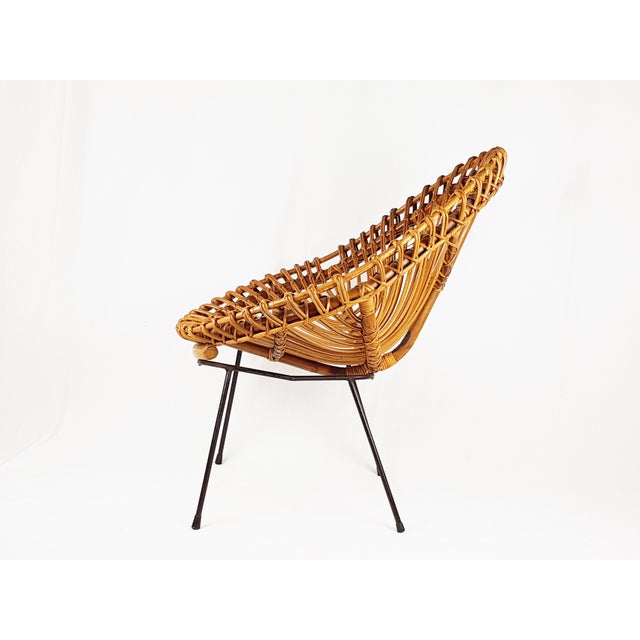 Italian armchair made from rattan seat and black metal iron legs. Very good condition: few rattan and paint losses;...