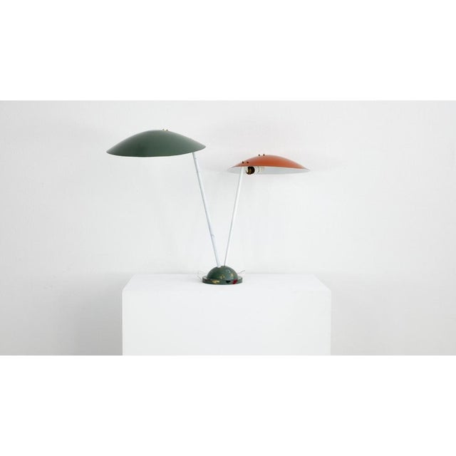 Italian lamp from the 1950s. The lamp has a white painted metal frame and a green and an orange painted aluminum...