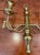 Offering a charming brass candle sconce in classic braid and tassel design.