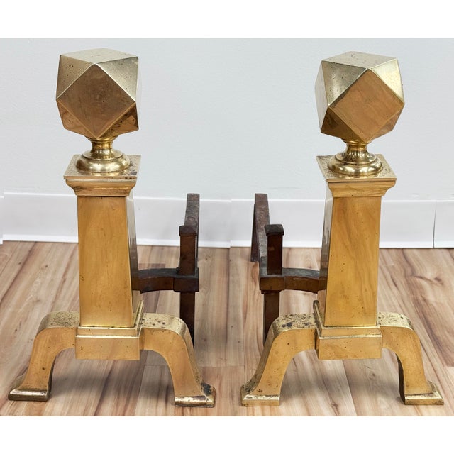Pair of antique cast brass andirons or chenets featuring octagonal shaped finials with angular bodies and feet. Cast brass...