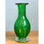 This vase presents a graceful, bulbous silhouette in richly saturated green glass, its rounded body swelling generously...